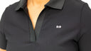 Close-up of a person wearing a black ribbed short-sleeve polo shirt with a white '2:9' logo on the chest, set against a plain white background.